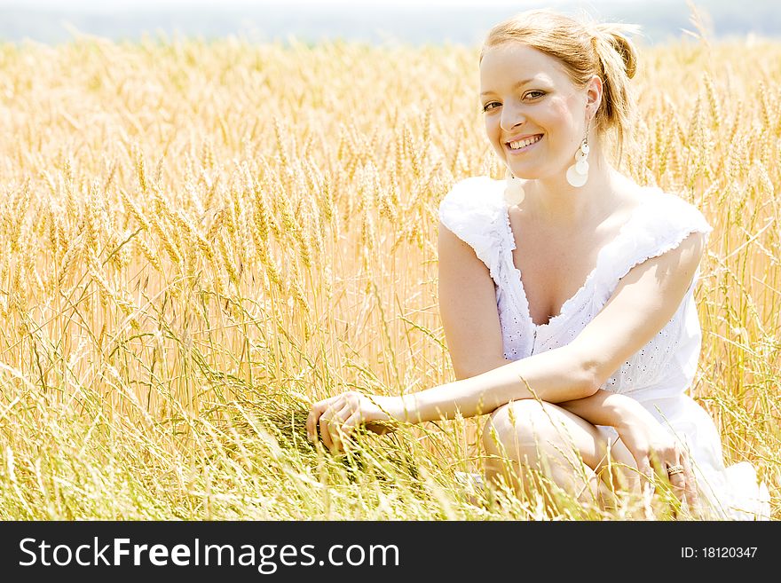 Portrait of woman sitting in grain field