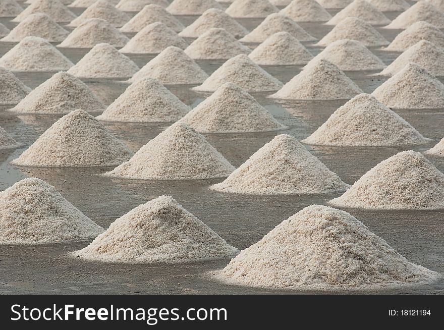 Saline in thailand . Farmer make heap of sea salt to preparation for packaging.