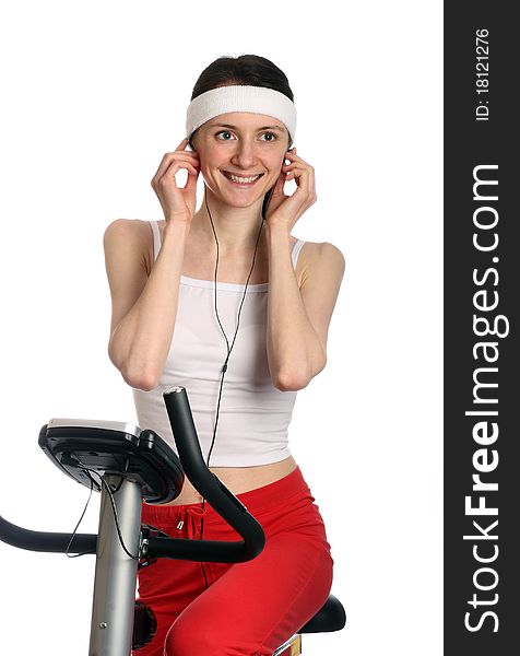 Happy young woman in red sport clothes on a training bicycle; isolated on white. Happy young woman in red sport clothes on a training bicycle; isolated on white