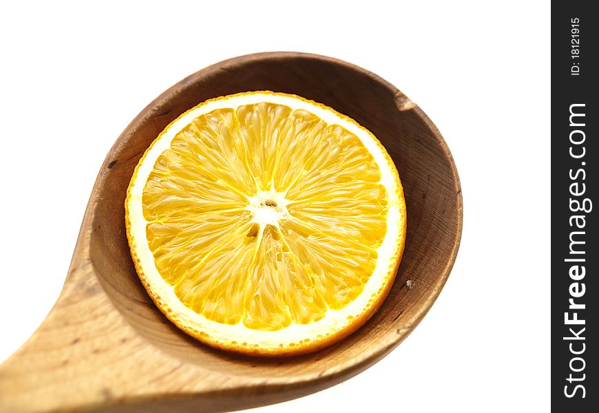 An orange slice in a wooden spoon