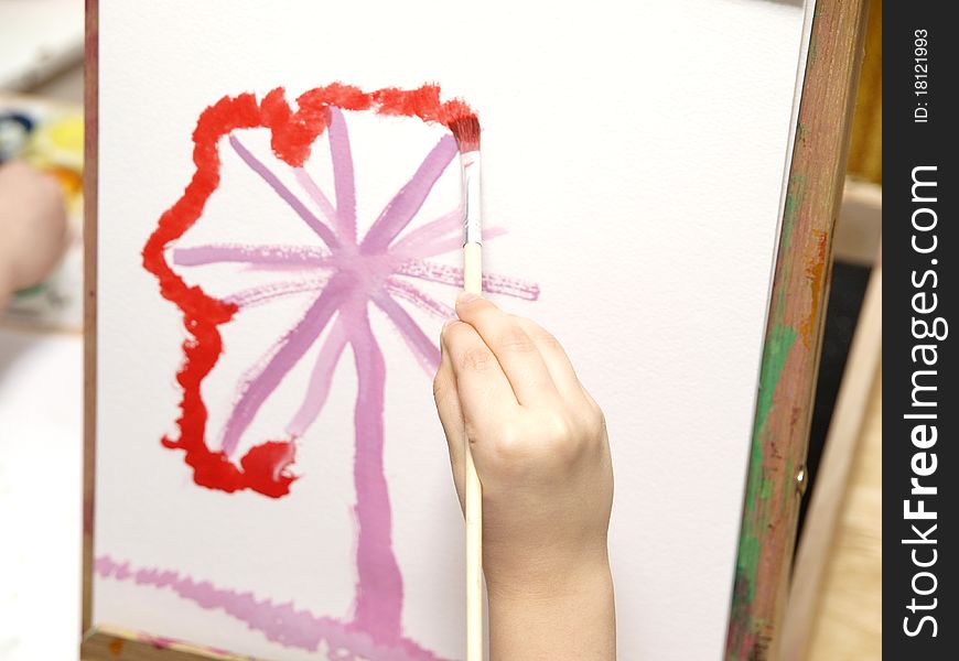 ChildÂ´s hand holding a paintbrush and painting. ChildÂ´s hand holding a paintbrush and painting