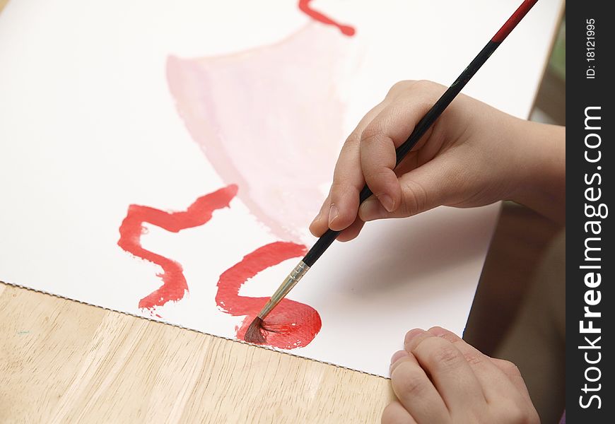 ChildÂ´s hand holding a paintbrush and painting. ChildÂ´s hand holding a paintbrush and painting