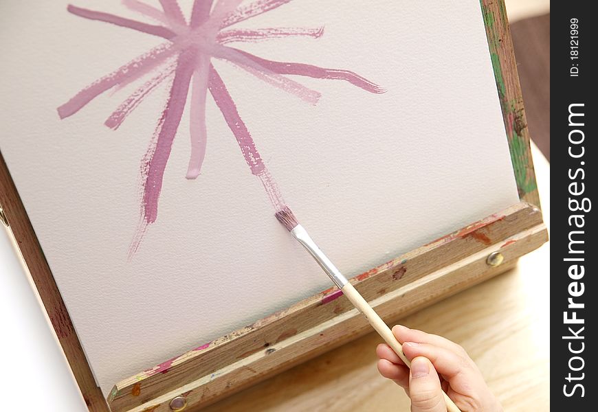 Child´s hand holding a paintbrush and painting. Child´s hand holding a paintbrush and painting