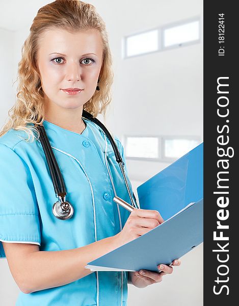 Beautiful young doctor with file folder and stethoscope in hospital