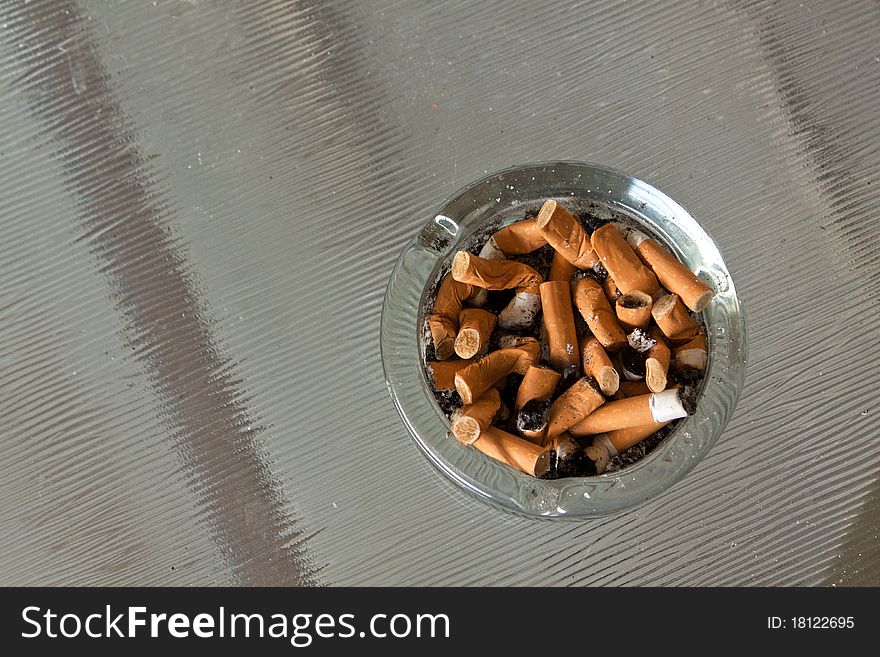 Close up view of cigarette butts in an ash tray.