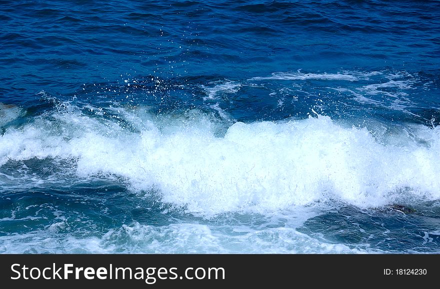 White wave at the dark blue seaside