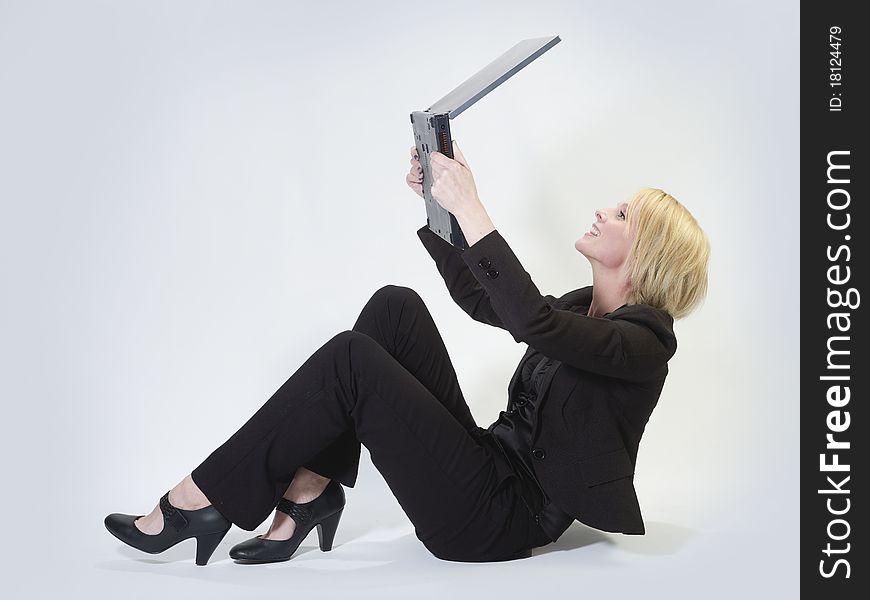 Businesswoman sitting and holding a laptop fixed