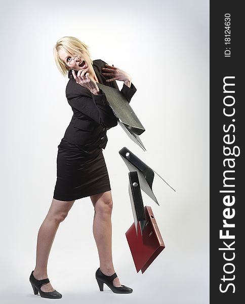 Busineswoman with cellphone and falling folders. Busineswoman with cellphone and falling folders
