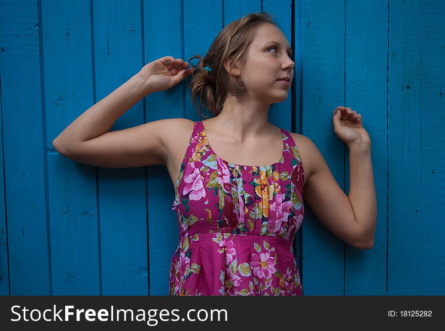 Girl in ethnic dress near blue wooden wall