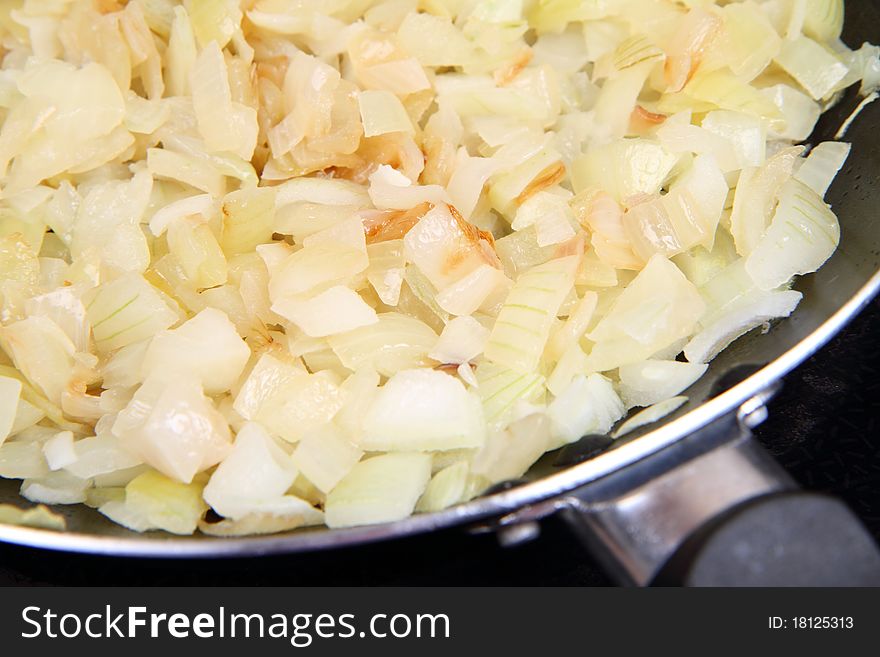 Onion being fried on a pan with. Onion being fried on a pan with