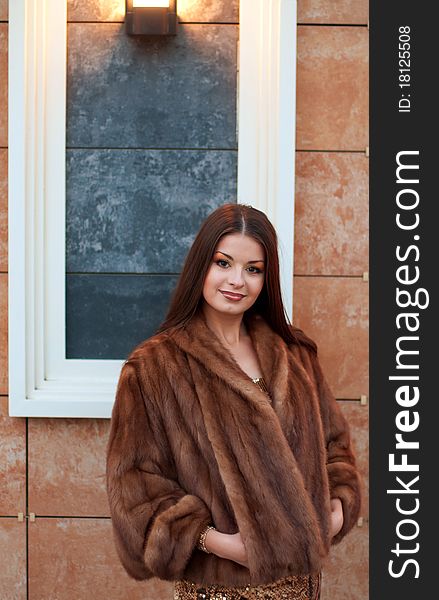 Portrait of luxurious young woman in a fur coat