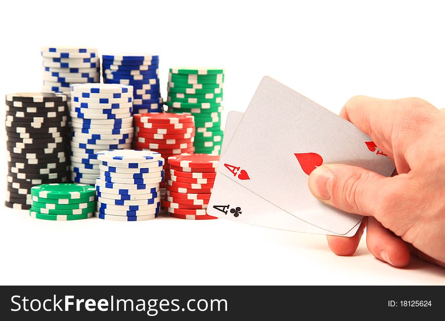 Hands of a man with a card and poker chips in the background.