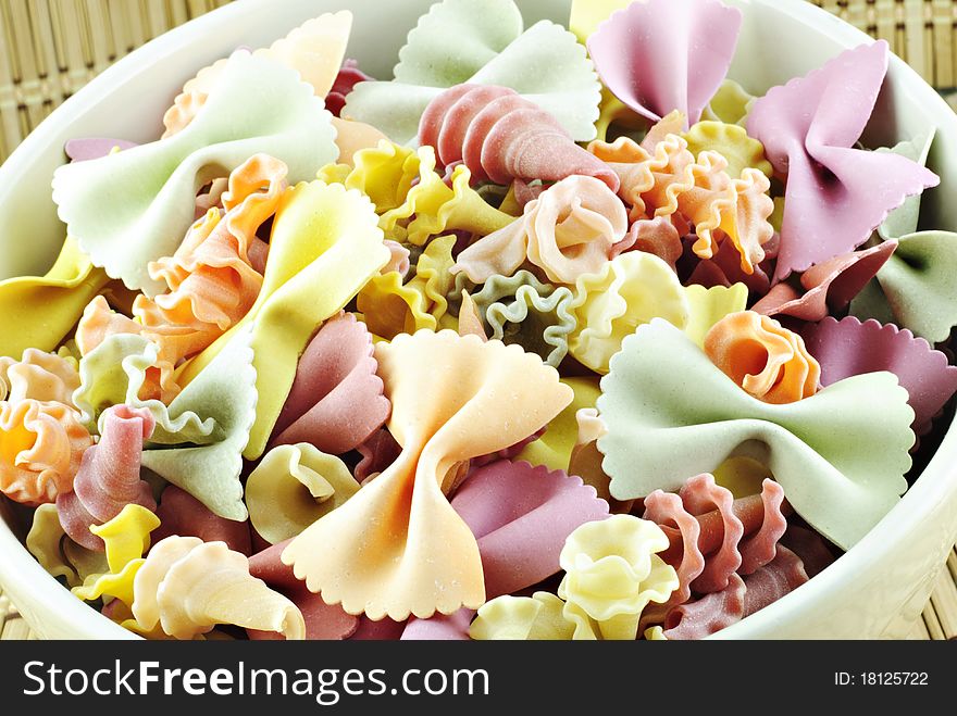 A bowl of colorful vegetable uncooked pasta in a bowl, closeup. A bowl of colorful vegetable uncooked pasta in a bowl, closeup