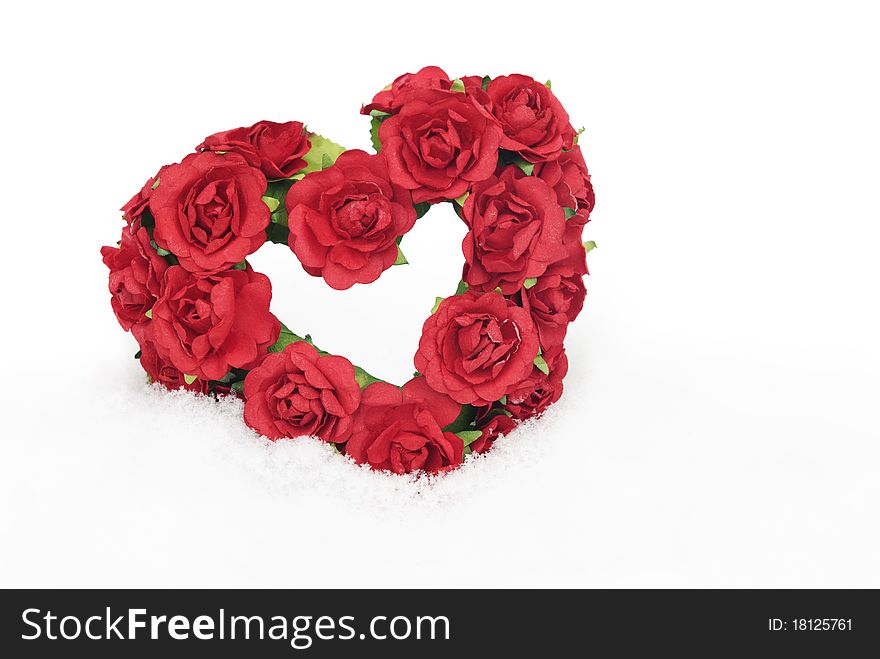 A red rose heart in the snow with lots of copy space, selective focus. A red rose heart in the snow with lots of copy space, selective focus