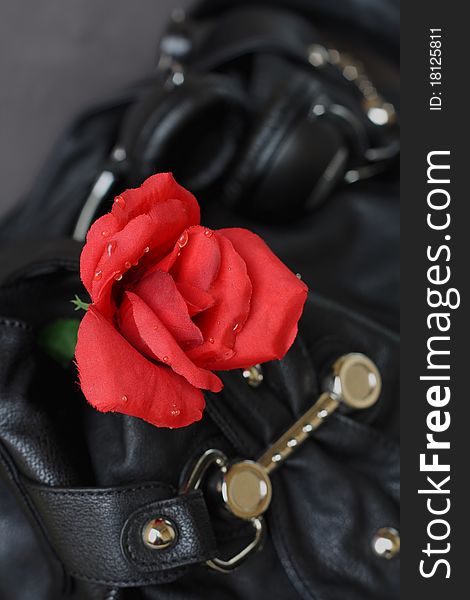 Red Rose of plastic on a black leather bag