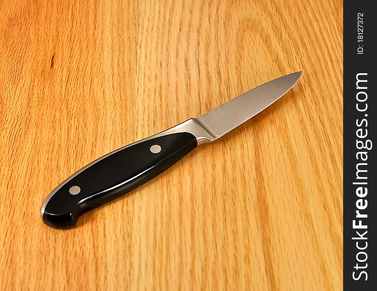 Kitchen paring knife on wooden table