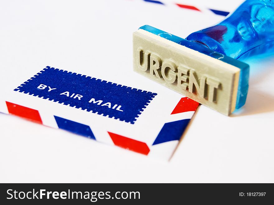 Urgent letter on rubber stamp on air mail envelope on white background. Urgent letter on rubber stamp on air mail envelope on white background