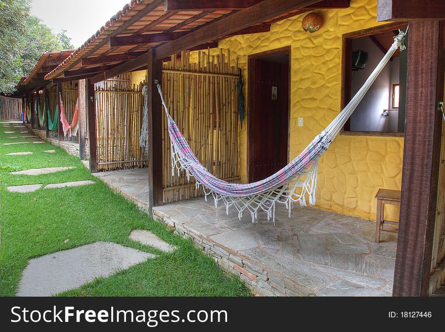 Line of hammocks hanging between posts at resort. Each hammock is different colored and styled. Line of hammocks hanging between posts at resort. Each hammock is different colored and styled