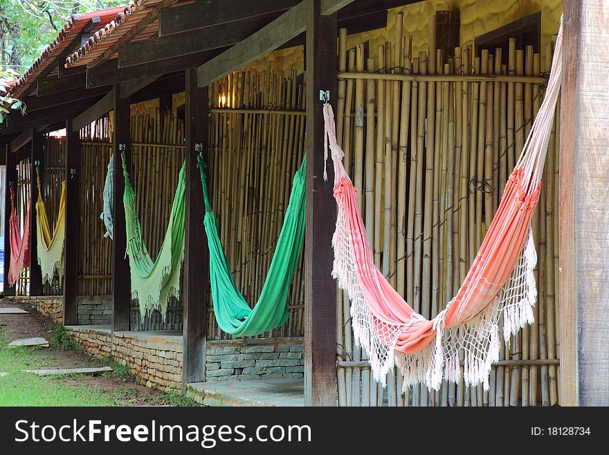 Line of hammocks hanging between posts at resort. Each hammock is different colored and styled. Line of hammocks hanging between posts at resort. Each hammock is different colored and styled