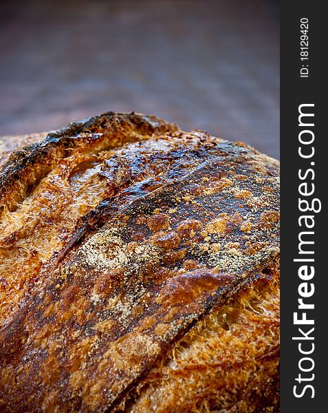 Close-Up of rustic sourdough bread on a wooden platter. Close-Up of rustic sourdough bread on a wooden platter