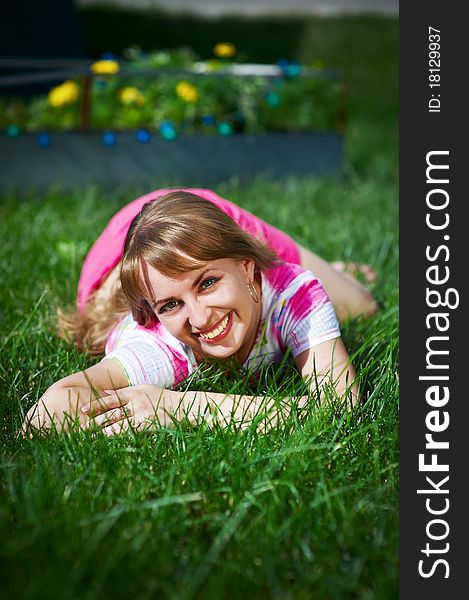 Joyful young woman on grass in park