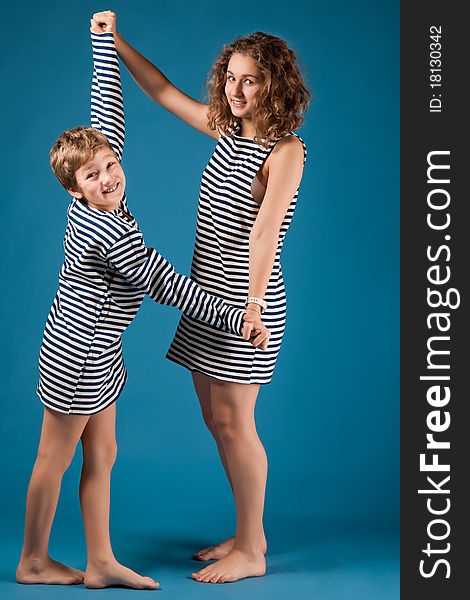 Cheerful children in stripped vests keep for hands