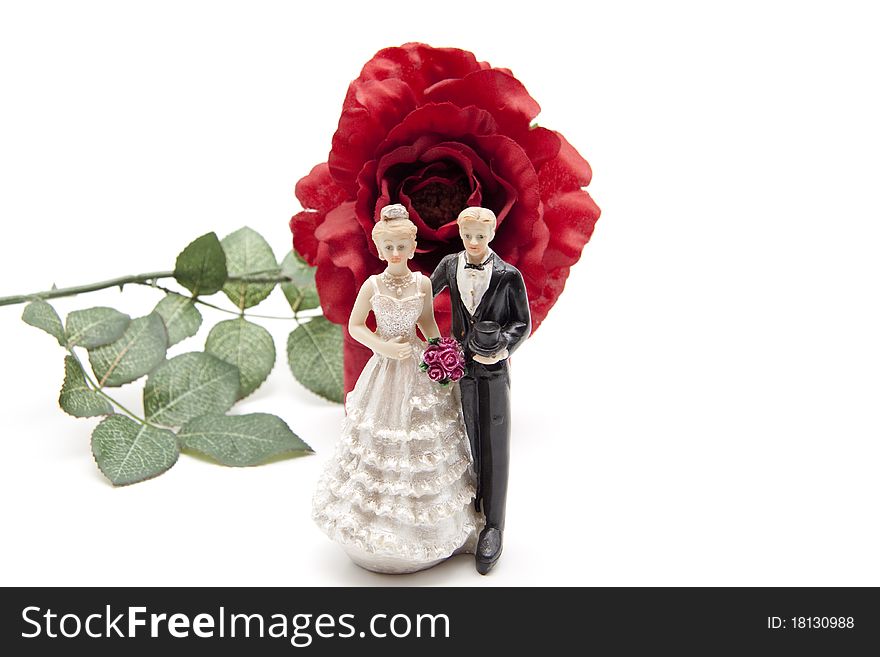 Bridal couple from ceramics in front of rose. Bridal couple from ceramics in front of rose