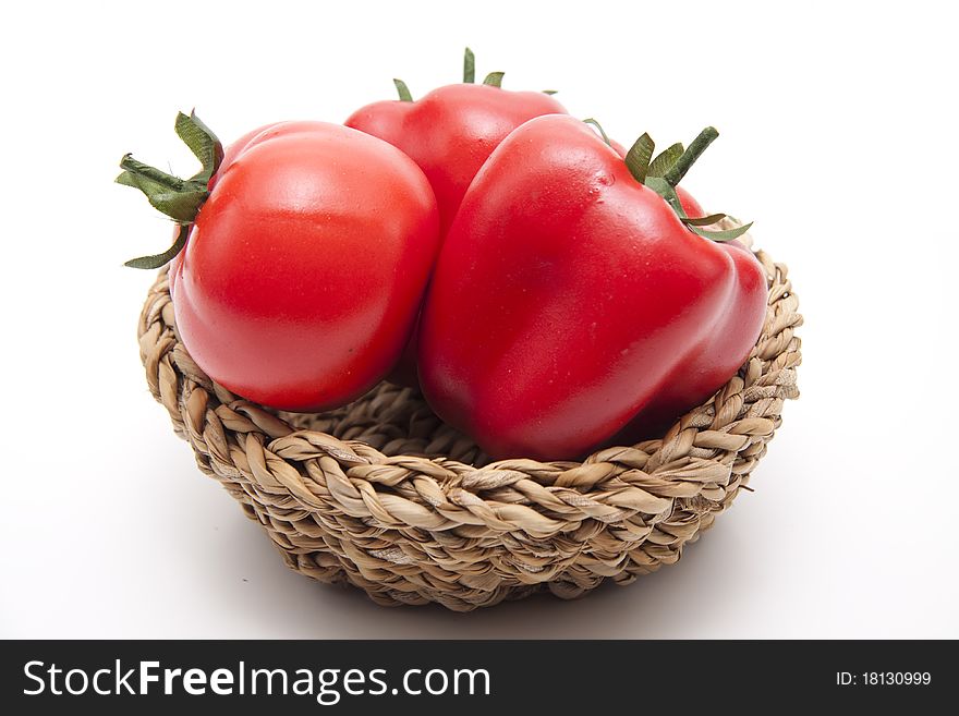 Tomato and red paprikas in the woven basket