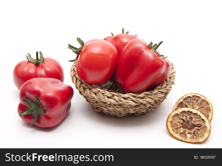 Tomato and red paprikas in the woven basket. Tomato and red paprikas in the woven basket