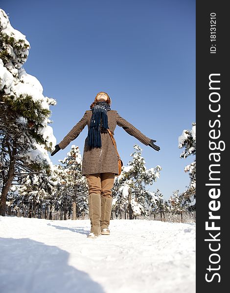 Beautiful young red-haired woman in winter park. Outdoor shot.