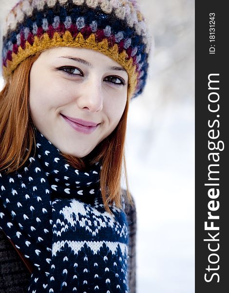 Beautiful young red-haired woman in winter park. Outdoor shot.