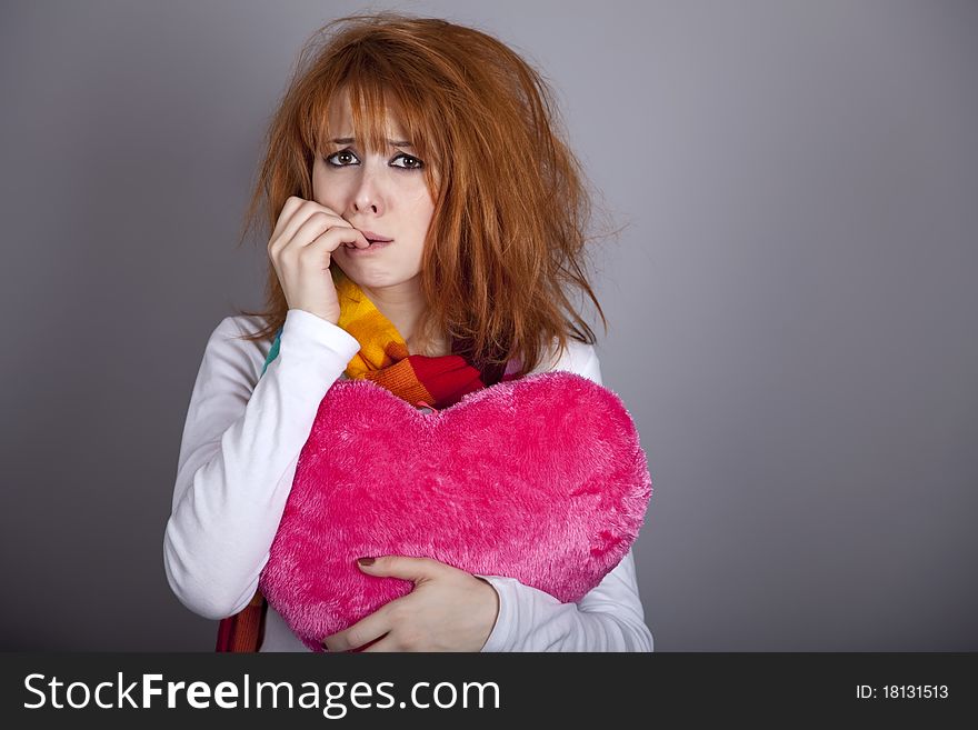 Sad girl with heart. St. Valentine Day. Studio shot.