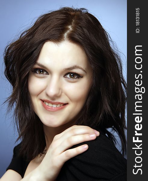 Beautiful woman brunette smiling, studio shot close-up, hand on shoulder