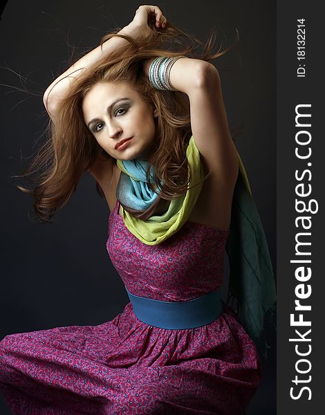 Sensual woman, with a hippie dress an multicolor scarf, playing with her hair, studio shot