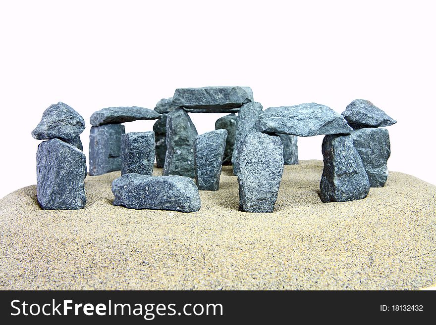 A miniature stonehenge look-alike made of small granite stones on white background