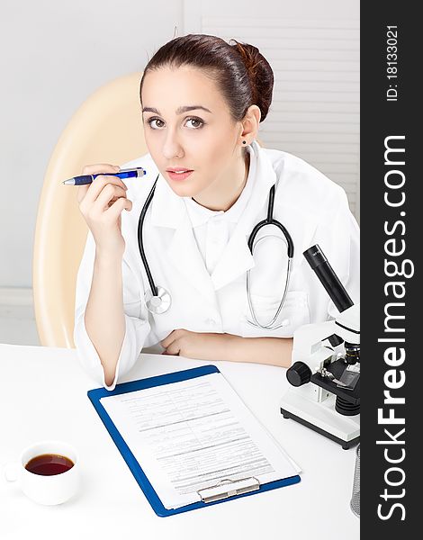 Female medical doctor working with a microscope. Female medical doctor working with a microscope