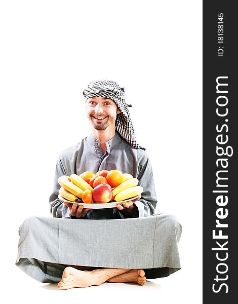 Young bedouin man in traditional dress with fruit