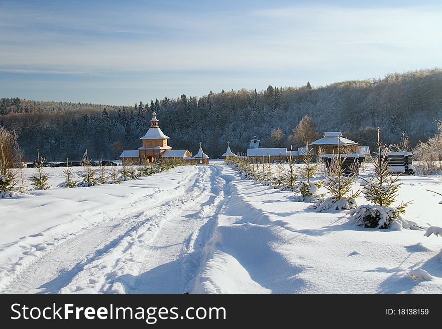 Snow-covered wooden church against winter wood. Snow-covered wooden church against winter wood