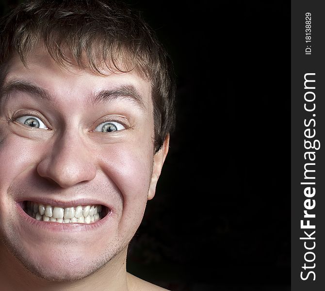 Portrait of a crazy or surprised guy close up. Isolated on a black background. Portrait of a crazy or surprised guy close up. Isolated on a black background