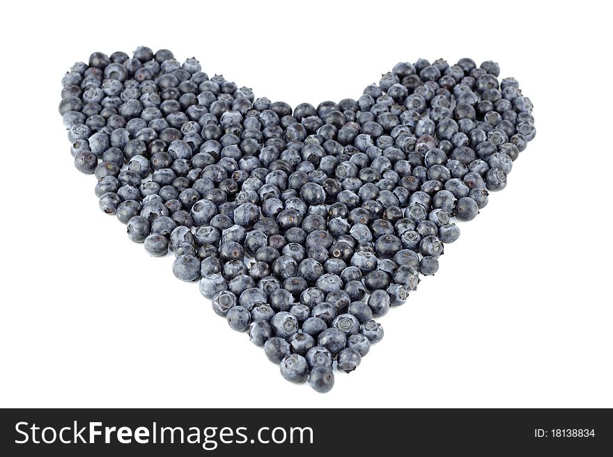 Natural blue purple fruit berry in the shape of large love on a white paper. Natural blue purple fruit berry in the shape of large love on a white paper.