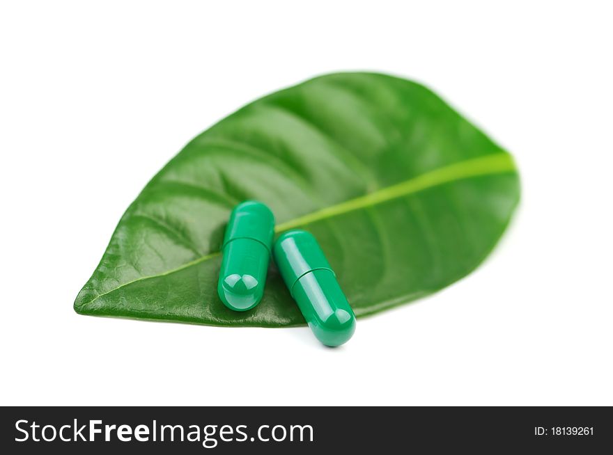 Pill with leaf isolated on white