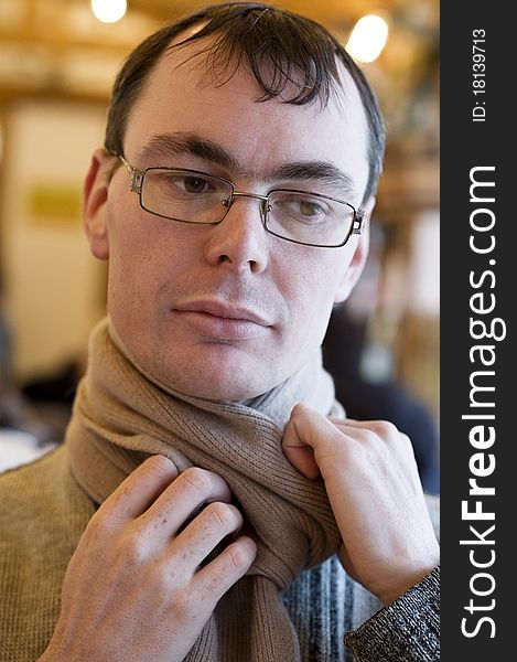 Portrait of adult man with glasses holding his scarf. Portrait of adult man with glasses holding his scarf