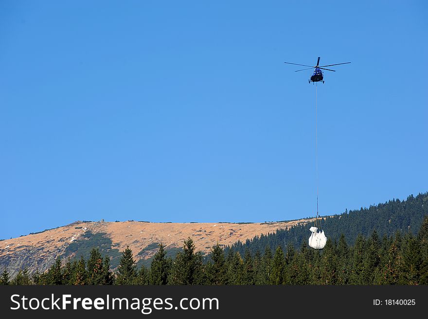 Helicopter with load. Branchers from mountain.