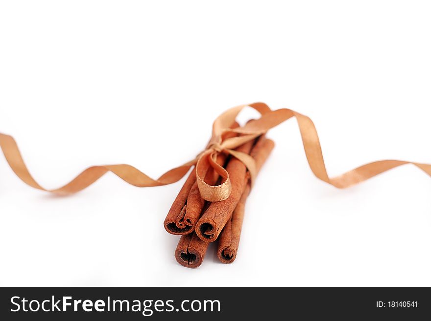 Cinnamon sticks bonded golden ribbon on a white background