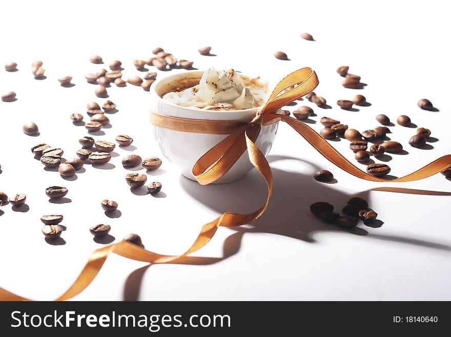 Cup of coffee with cream and golden ribbon