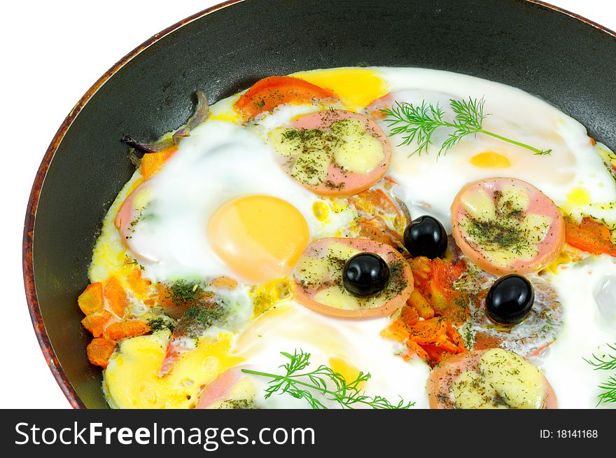 Fried eggs with vegetables in a black skillet