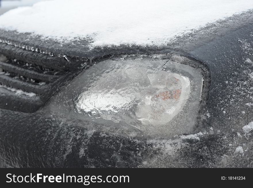 Frozen car: ice on a headlight
