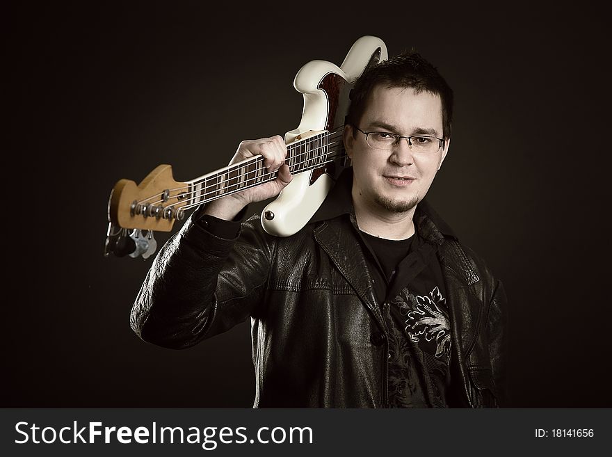 Portrait of young guitarist on the black background. Portrait of young guitarist on the black background