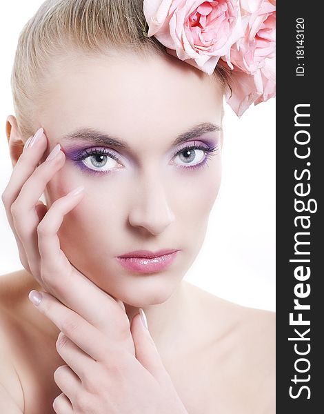 Portrait of young beautiful woman with roses in hair, on white background