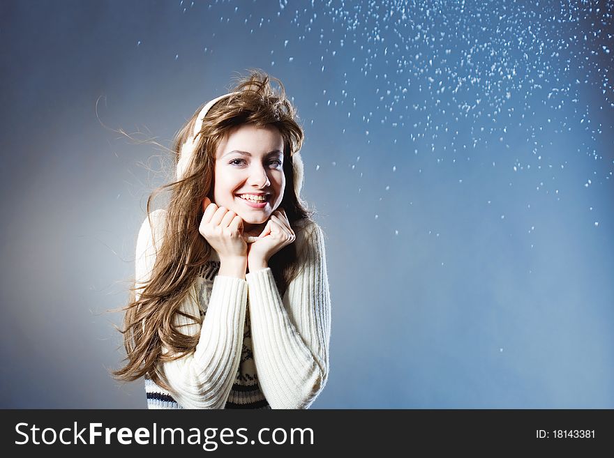 Young beautiful girl rejoices to snow, On a dark blue background